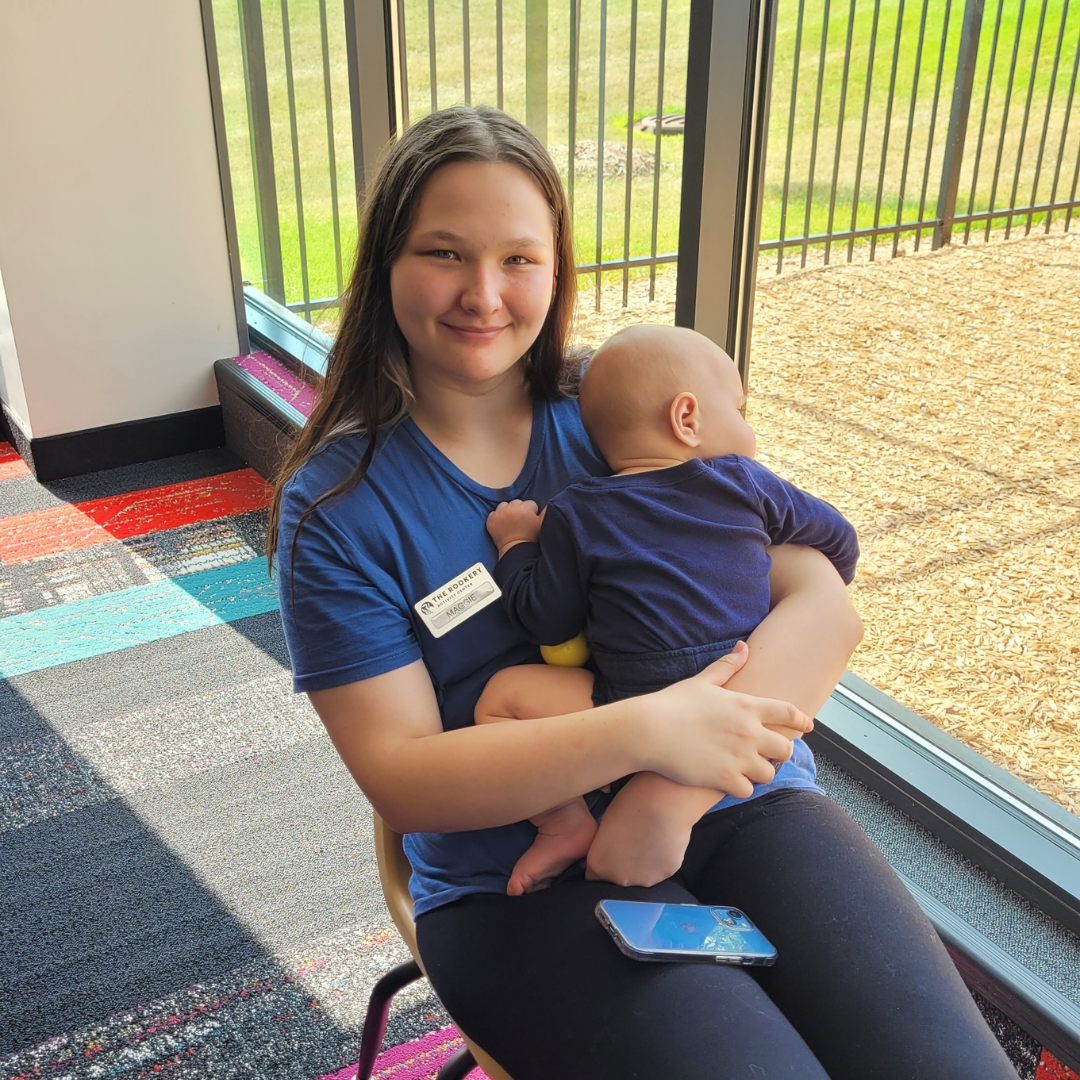 Woman sitting in chair holding an infant